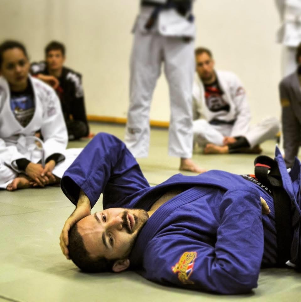 Lorenzo in a blue jiu jitsu gi, taking a breather on the mat